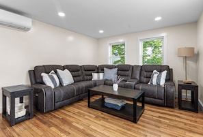 A sectional sofa with a dark finish, a coffee table, a side table, and a lamp. - 3BR near Acadia & Bar Harbor sleeps 8 - AC - WiFi - Deck (Ellsworth)