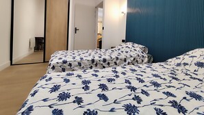 Ein Schlafzimmer mit einem großen Bett, einem Kleiderschrank und einem Spiegel.