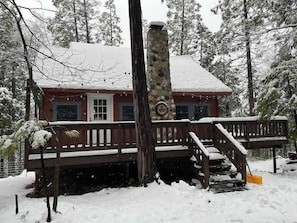 A cabin with a stone chimney, a wooden deck, and a snow-covered roof. - Daisy’s Place | Cozy Twain Harte Cabin w/ Twain Harte Lake Access (Twain Harte)