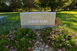 Señal de bienvenida a Larkey Park con un jardín delantero.