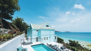 Una casa moderna con piscina, balcón y vista al océano.
