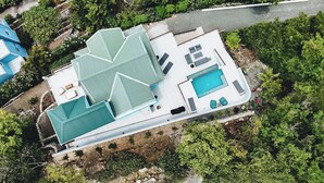 Vista aérea de una casa con piscina, varias habitaciones y jardín.