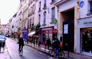 A street with buildings, a 'HOTEL' sign, and a 'LOREM DOLORIS' shop. - LOCATED ON THE PRESTIGIOUS RUE DAUPHINE IN THE HEART OF SAINT-GERMAIN (Paris)