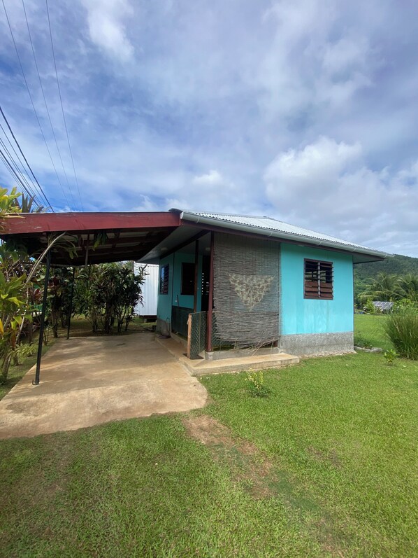 A single-story building with a covered porch, a small window, and a door.