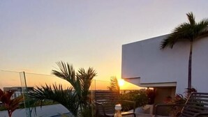 A tray with food and drinks on a table with a view of the sunset. - Sensai Downtown by Riviera Maya Suites  (Playa del Carmen)