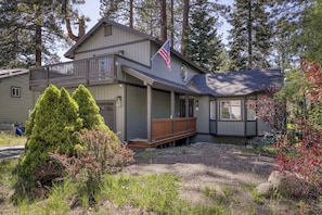 A two-story house with a balcony, a flag, and a well-maintained garden. - Peaceful Tahoe escape next to protected forest land, minutes from beaches, trails, and adventure (South Lake Tahoe)