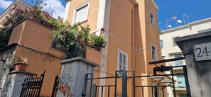 A building with a beige facade, a gate with a number '24' sign, and some greenery on the balconies. - Tranquility and comfort near Trastevere (Roma)