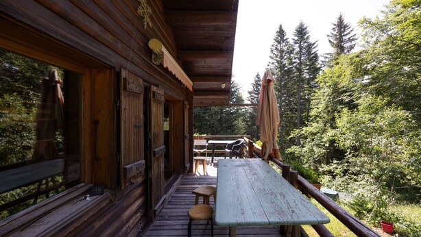 A wooden deck with a picnic table, benches, and a view of the forest. - Bed and Breakfast 'Chambre' with Wi-Fi (Montcel)