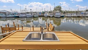 A marina with boats docked, a wooden pier, and a metal dock with a sink. - Gulf Access Getaway, 4 Kayaks, Dock, Fire Pit & Waterfront Fun, Boat Dock, FirePit, Bikes (Hernando Beach)