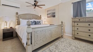 A bedroom with a bed, bedside table, lamp, ceiling fan, dresser, and a painting on the wall. - Gulf Access Getaway, 4 Kayaks, Dock, Fire Pit & Waterfront Fun, Boat Dock, FirePit, Bikes (Hernando Beach)