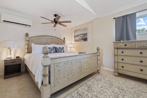 A bedroom with a bed, bedside table, lamp, ceiling fan, dresser, and a painting on the wall. - Gulf Access Getaway, 4 Kayaks, Dock, Fire Pit & Waterfront Fun, Boat Dock, FirePit, Bikes (Hernando Beach)