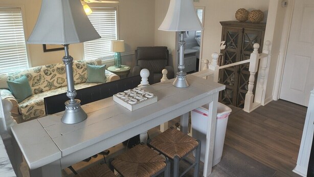 A room with a white table, two lamps, a chessboard, a sofa, and a cabinet. - 2 Bedroom home with Golf Cart! (Panama City Beach)