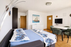 Ein Hotelzimmer mit einem Bett, einem Schreibtisch, einem Stuhl, einem Fernseher und einem Bild an der Wand.