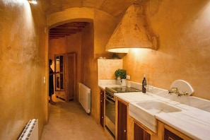 A narrow hallway leading to a kitchen with wooden cabinets, a stove, and a sink. - Farmhouse with pool, bath and spectacular views (Villahermosa del Río)