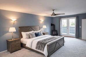 Ein Schlafzimmer mit Bett, Nachttischen, einem Heizkörper und einem Deckenventilator.