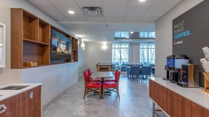 A modern coffee shop with a counter, seating area, and a wall with a coffee advertisement. - Cozy 1-bedroom, 2 queen bed, hotel suite with AC in soothing Downtown Ashville (Ashville)