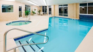 An indoor swimming pool with clear lanes, a lifeguard chair, and a small seating area with chairs. - Cozy 1-bedroom, 2 queen bed, hotel suite with AC in soothing Downtown Ashville (Ashville)
