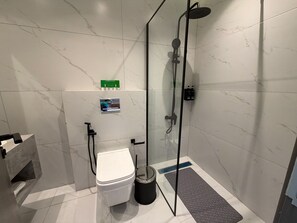 A modern bathroom with a glass-enclosed shower, a toilet, and a bidet. - 406 Tara-jre Jabal Al Lweibdeh With Stunning View (Amman)