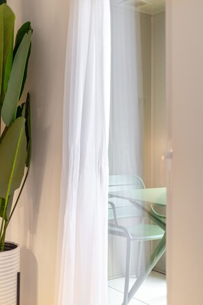 A room with a potted plant, a glass table, and a chair. - Old Port 2BR | Pool Gym Parking (Montreal)