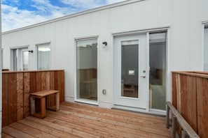 A building with a wooden deck, white exterior walls, and large glass doors. - MTL Trendy Hideaway in Rosemont (Montreal)