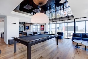 A modern indoor pool table with a high ceiling and large windows. - Charming 2BR Apt in DT MTL (Montréal)