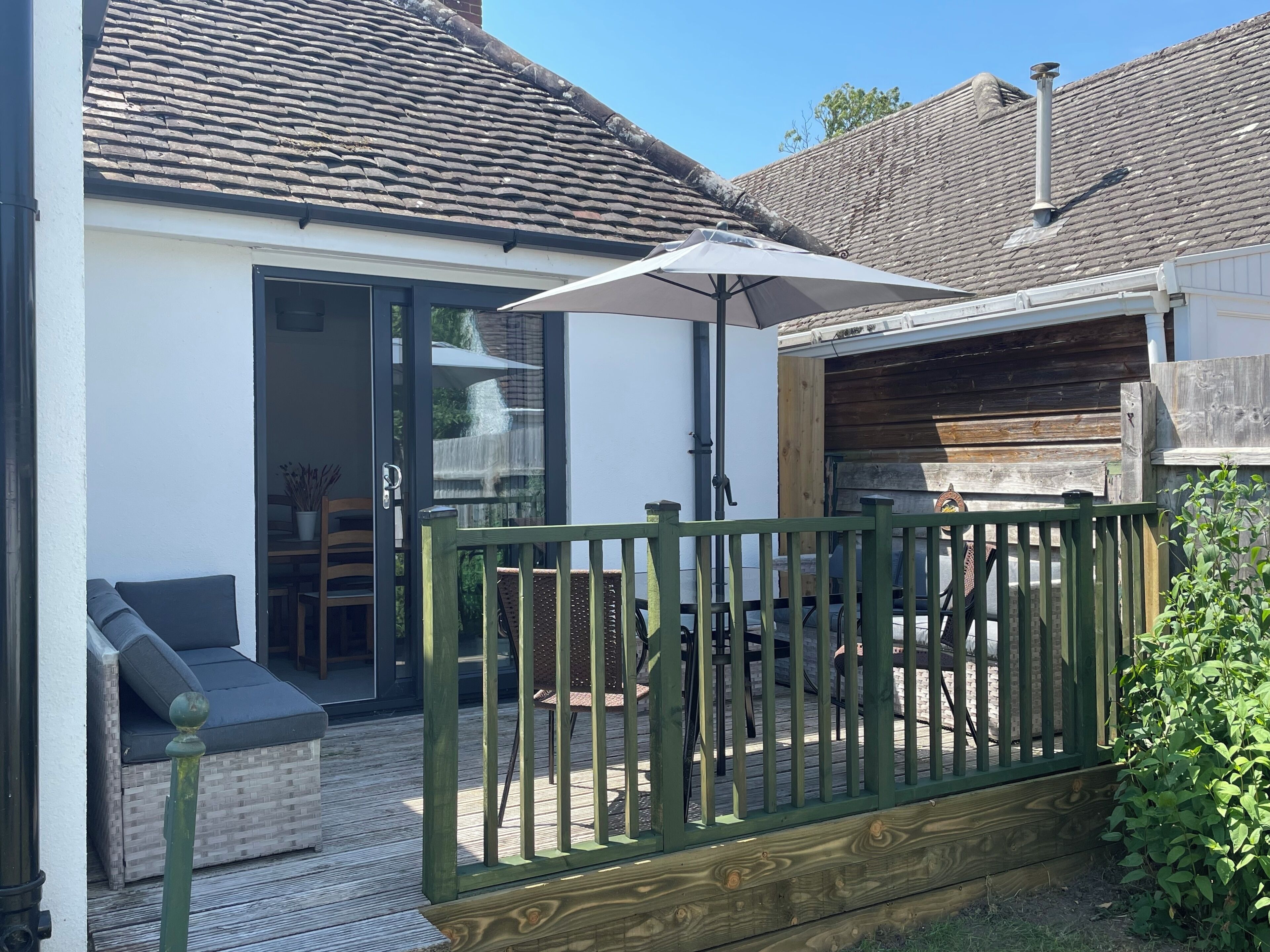 A patio with a wooden fence, a table, and chairs.