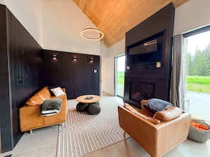Ein modernes Wohnzimmer mit einer Couch, einem Couchtisch und einem Kamin.