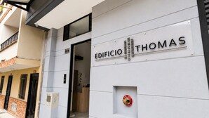 A building with a sign reading 'EDIFICIO THOMAS' and a fire hydrant on the wall. - Apartaestudio Luxury (Sabaneta)