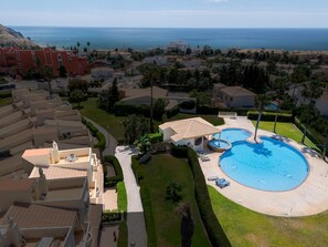 Ein Resort mit Pool, überdachtem Bereich und Meerblick.