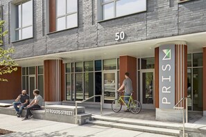 Ein Gebäude im modernen Stil, mit einem Fahrradstellplatz und einem Schild mit der Nummer 50.