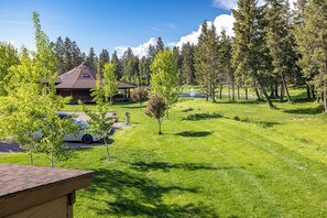 A lodge with a large roof, a covered patio, and a pond. - Strawberry Moon in Whitefish with Hot Tub (Whitefish)