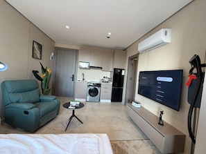 A modern living room with a sofa, a coffee table, a TV, and a kitchen in the background. - 408s Tara-jre Jabal Al Lweibdeh With Stunning View (Amman)