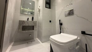 Une salle de bain moderne équipée de toilettes, d’un lavabo et d’un espace douche.