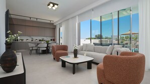 Ein moderner Wohnbereich mit einer Couch, Sesseln, einem Couchtisch und einem Esstisch.