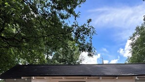 Et lille hus med en hvid dør, et skilt der siger 'WELCOME', og en brostenssti, der fører til indgangen.