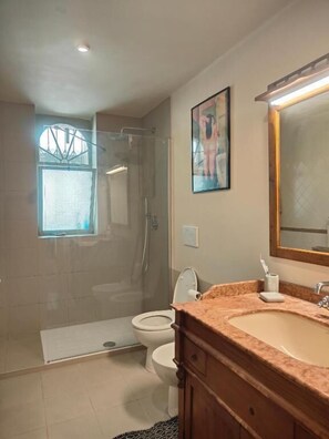 A bathroom with a shower, toilet, sink, and a large mirror. - Casa Amapola Bari (Bari)