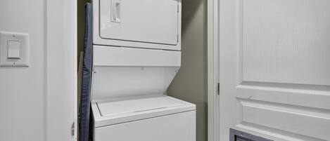 A white wall-mounted washer and dryer unit with control knobs and a door.
