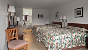 Ein Hotelzimmer mit einem Bett, zwei Nachttischen, einem Sessel, einem Schreibtisch mit Lampe und einem Spiegel.