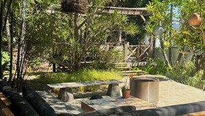 An outdoor seating area with a bench, a table, and a trash can. - Fantastic studio with AC in vibrant Los Angeles neighborhood. (Los Angeles)