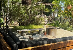 An outdoor seating area with a bench, a table, and a trash can. - Fantastic studio with AC in vibrant Los Angeles neighborhood. (Los Angeles)
