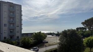 A residential building with multiple floors, a parking area, and a view of the sea. - M470 - Marcelli, three-room apartment with sea view (Marcelli)