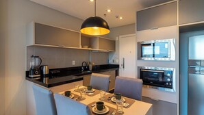 A modern kitchen with built-in appliances, a dining area with a table set for two, and a large pendant light. - House in Condo. w/ Garage in Salvador Tstedf0401 (Salvador)