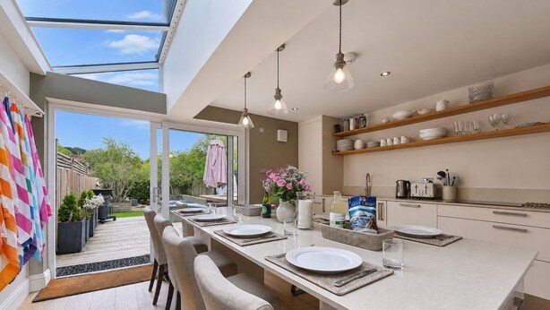 A modern kitchen with a central island, pendant lighting, and a view of the outdoors. - Hydrangea House -  a managed house that sleeps 10 guests  in 4 bedrooms (Hythe)