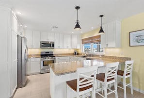 A kitchen with white cabinets, a granite countertop, stainless steel appliances, and pendant lighting. - Cozy Coastal Luxury Home w/ Dock + Panoramic Views (Stafford Township)