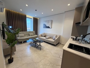 A modern living room with a sofa, coffee table, and a potted plant. - 413 Tara-jre Jabal Al Lweibdeh With Stunning View (Amman)