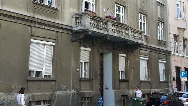 A multi-story building with a balcony, a fire hydrant, and a parked car. - Studio Apartments City&style (Zagreb)