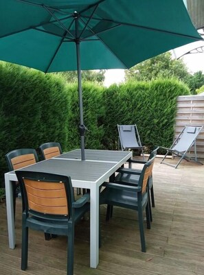 An outdoor patio with a table and chairs, a green umbrella, and a wooden deck. - BOIS FLOTTE - VIELLE SAINT GIRONS (VIELLE SAINT GIRONS)