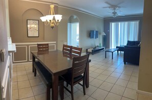 A dining area with a large table and chairs, a chandelier, and a ceiling fan. - Spacious 3-bedroom apartment, in the best community from Disney. (Kissimmee)
