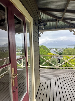 A wooden deck with a view of a lake and mountains.