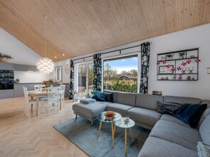 Ein modernes Wohnzimmer mit einer Couch, einem Esstisch und einer Küchenzeile.